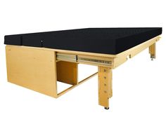 a wooden table with an open drawer on it's side and black fabric under the top