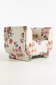 a white chair with flowers on the back and arm rests in front of a white background