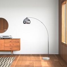 a living room with a wooden floor, white walls and a round mirror on the wall