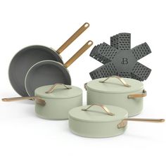 an assortment of pots and pans with wooden spoons in them on a white background