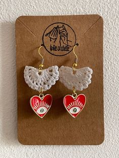 two heart shaped earrings on top of a card