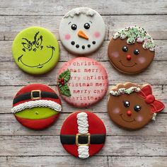 six decorated christmas cookies sitting on top of a wooden table