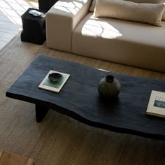 a living room with a couch, coffee table and book on the floor in front of it