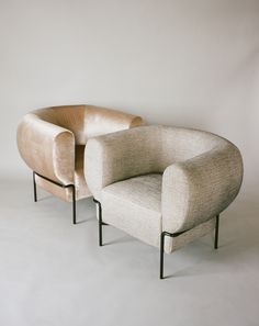 two chairs sitting next to each other on a white floor