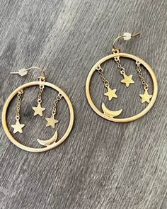 Add a touch of celestial magic with our Starry Eyed Surprise earrings! These gold hoops feature delicate moons and stars for a truly unique look. Shine bright like the stars and make a statement with these playful and versatile accessories. (Moon and stars included!) Trendy Metal Hoop Earrings With Star Charm, Trendy Gold Crescent Earrings, Trendy Gold Earrings With Star Charm, Celestial Style Metal Dangle Hoop Earrings, Gold Star Hoop Earrings For Party, Trendy Gold Hoop Earrings With Star Charm, Hoop Jewelry With Star Charm In Metal, Gold Moon Shaped Pierced Hoop Earrings, Adjustable Celestial Hoop Earrings