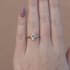 a woman's hand with a ring on it and a diamond in the middle