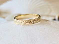 a gold wedding ring sitting on top of a white pillow