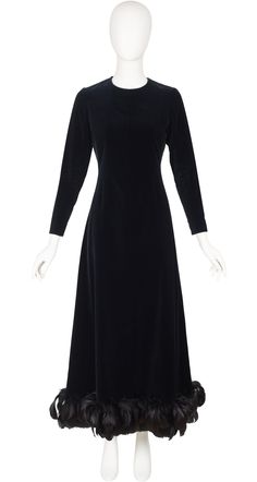 "This Givenchy Nouvelle Boutique long-sleeved evening gown is numbered, completely hand-finished demi-couture. It was made in France in the late-1960s/early-1970s of a black 78% cotton/22% viscose velvet blend, with a rayon lining and a feather trim hemline. It fastens at the back, and each cuff, with hand-set metal Eclair zippers. It's in overall very good condition. There are a few feathers missing but it's very discreet. Measurements:  Bust - 34\" Waist - 29\" Hips - 37\" Shoulders - 14\" Sle Classic Long Sleeve Dresses For Gala, Evening Long Sleeve Dress With Fitted Bodice, Winter Evening Maxi Dress, Classic Fitted Long Sleeve Dress For Evening, Winter Evening Floor-length Dress, Floor-length Evening Dress For Winter, Floor-length Winter Evening Dress, Classic Floor-length Maxi Dress For Evening, Classic Floor-length Evening Maxi Dress