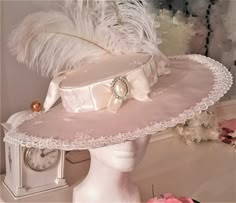 Belle Epoque Style Ladies Kentucky Derby Hat in a luminous Cream Taffeta w/ Fleur de Lis embroidery, ivory lace edging, faux pearl and Swarovski Crystal Front Brooch & Ostrich Plumes. This hat has a French sensibility, with 16 inch diameter and a crown diameter of 7 inches. Of it's many virtues, this hat is extremely versatile for a costumer, covering several fashion periods efortlessly ( Belle Epoque, Rococo, Georgian or Early Modern.) Kentucky Derby Style, Ladies Hat, Satin Ribbon Bow, Kentucky Derby Hat, Derby Hat, Fancy Hats, Pearl Cluster, Derby Hats, Fantasy Fashion