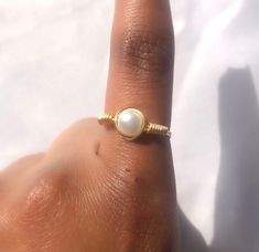 This simple gold, dainty, faux pearl ring is handmade out of wire, this ring is sturdy but can be bent, so a lot of force should not be applied to this! You only get 1 ring per purchase. I also sell matching pearl earrings, a simple pearl necklace and bridal pearl necklaces, these are all perfect to wear throughout the summer.  SIZING: - US 4 --- UK H--- Pandora size 46 --- 14.60mm (diameter) - US 4 1/2 --- UK H1/2 - I1/2 --- Pandora size 48 --- 15.30mm  - US 5 --- UK J-K --- Pandora size 50 --- 16.00 mm - US 5 1/2 --- UK K-L --- Pandora size 51 - 16.2 mm - US 6 --- UK L - L1/2 --- Pandora size 52 ---16.50mm - US 6 1/2 --- UK M --- Pandora size 53 --- 16.9mm - US 7 --- UK N --- Pandora size 54 --- 17.20mm - US 7 1/2 --- UK O - P --- Pandora size 56 --- 17.80mm - US 8 --- UK P --- Pandora s Adjustable Dainty Toe Ring Jewelry, Dainty Adjustable Toe Ring Jewelry, Minimalist Adjustable Pearl Rings, Adjustable Minimalist Pearl Ring, Dainty Gold Plated Toe Ring Jewelry, Wire Wrapped Round Pearl Jewelry, Hypoallergenic Dainty Ring Jewelry, Elegant Adjustable Tiny Pearl Ring, Minimalist Stackable Adjustable Pearl Ring