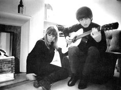 two people sitting on the floor playing guitars