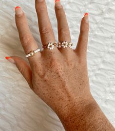 ✿ White & Gold Daisy Beaded Ring - stretchy & stackable! ✿  Choose from the the following styles: * 1 - White Daisy/Gold band * 2 - Gold Flower/White Band * 3 - Multi Flower Daisy 📏 Size: - fits ring sizes 5.5 - 8 - made with stretchy string to make sizing pretty flexible - please dm me for any personalization or specific size request! 💍 Material: - 3 mm glass seed beads - Gold beads - Stretch 1 mm bead string tied & glued 📦 Shipping & Returns: - Rings are made to order, it could sometimes ta Handmade Adjustable White Pearl Ring, White Beaded Wedding Rings, Adjustable Hypoallergenic White Pearl Ring, Handmade Adjustable White Flower Ring, Adjustable Handmade White Flower Ring, White Inelastic Beaded Jewelry, Adjustable White Handmade Flower Ring, Adjustable White Flower Shaped Ring, Adjustable White Flower Ring