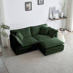 a living room with a large green couch and white rugs on the floor in front of a window