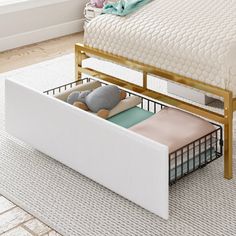 a white bed with a metal frame and storage underneath it