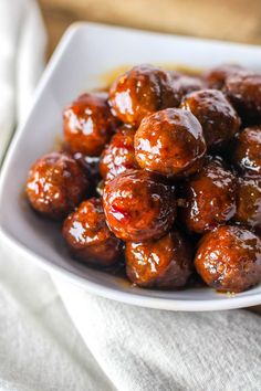 a white bowl filled with meatballs covered in sauce