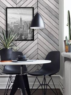 a dining room table with two chairs and a potted plant in front of it