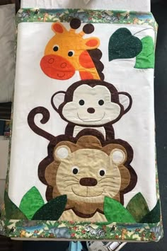 there is a blanket with animals on it and one has a giraffe, monkey, and zebra