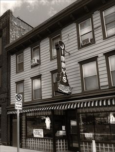 a black and white photo of the outside of a building with a sign on it