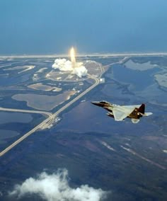 an airplane flying in the air with a rocket behind it