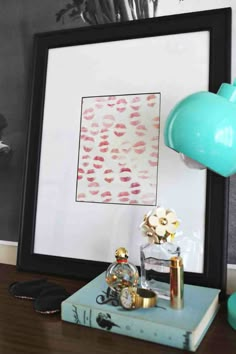 a framed photograph sitting on top of a wooden table next to a clock and lamp