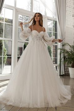 a woman in a white wedding dress posing for the camera