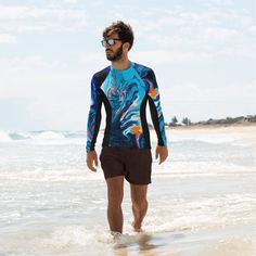 "There's nothing worse than sunburn, or bruises ruining a day filled with sports. But that's where this smooth and long-sleeved rash guard comes in play! It's slim-fitted, a bit longer than a casual tee, and tailor-made to protect from the sun, wind, and other elements while doing sports. Not to mention that it yields vibrant prints that'll get noticed. It has a four way stretch to allow the garment to hug and move with the body. It is moisture wicking, breathable and quick drying. Our rashguard Upf 50+ Crew Neck Swimwear, Crew Neck Swimwear With Upf 50+, Blue Rash Guard With Uv Protection For Water Sports, Crew Neck Swimwear For Surfing In Summer, Summer Surfing Swimwear With Crew Neck, Summer Beach Crew Neck Rash Guard, Summer Beach Rash Guard With Crew Neck, Crew Neck Moisture-wicking Rash Guard For Swimming, Crew Neck Rash Guard With Moisture-wicking For Swimming