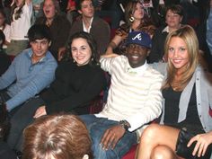 a group of people sitting next to each other in front of a man and woman