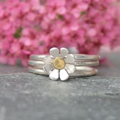 These sterling silver daisy stacking rings would make a wonderful gift for a nature lover.  I hand make each set to order in your size which you can select from the menu.  Daisies are the April birth flower making these stacking ring a great gift idea.   They are created from sterling silver and the centre one has a silver daisy with a brass centre.  These rings can be worn together as a set or individually.  The sterling silver has been recycled making these rings a thoughtful gift for some one Stacking Rings Silver, Silver Wedding Anniversary Gift, April Birth Flower, Silver Flower Ring, Artisan Jewelry Handmade, Daisy Jewelry, Daisy Design, Daisy Ring, Sterling Silver Stacking Rings