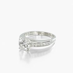 a white gold ring with diamonds on the side and an oval cut diamond in the middle