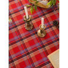 a table topped with two candles next to a plate of food and a book on top of it