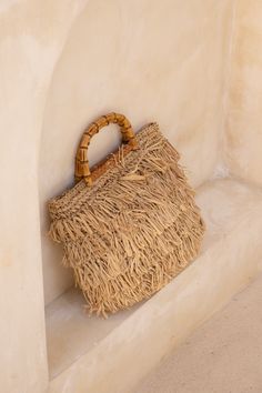 Expertly crafted by Lusana, the Aylin Fringe Basket Tote blends straw and trendy fringe accents to create a stunning design. Featuring an open top and adorned with faux bamboo wood-tone handles and leather trim details, this bag is perfect for your next European getaway. Chic Beige Fringe Bag, Rectangular Beige Bag With Fringe, Beige Rectangular Bag With Fringe, Beige Rectangular Fringe Bag, Summer Rectangular Bag With Tassels, Daily Use Rectangular Bucket Bag With Fringe, Beige Jute Top Handle Bag, Summer Fringe Rectangular Bag, Summer Fringe Rectangular Bags