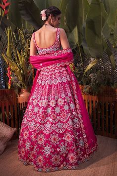 Magenta pink lehenga with mirror work, thread embroidery and foil motifs. Comes with blouse and dupatta.
Component: 3
Pattern: Embroidery
Type Of Work: Mirror, Thread, Gota Patti and Foil
Neckline: Sweetheart
Sleeve Type: Sleeveless
Fabric: Organza
Color: Pink
Other Details: 
Scallop detail on the neckline and hem
Dupatta with scallop and cutwork border
Note: Blue lehenga set worn by the other model is not for sale
Occasion: Bride - Aza Fashions Pink Fitted Dress With Motifs, Fitted Pink Anarkali Set With Motifs, Wedding Dresses With Motifs, Pink Wedding Choli With Motifs, Pink Saree With Motifs, Pink Saree Dress With Motifs, Wedding Sets With Pink Motifs, Pink Motif Anarkali Set For Wedding, Pink Anarkali Set With Motifs For Wedding