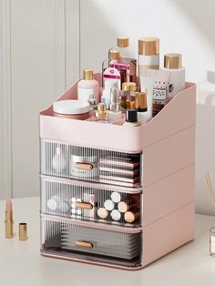 a pink makeup organizer on a white table