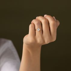 a woman's hand with a diamond ring on it