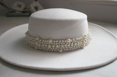 Beautiful White Pearl Wedding Hat. Why not chose an alternative to your traditional wedding veil?  If you're the cool modern boho bride chose from one of our bridal hats, you will not be disappointed. Our wedding hats are a perfect accessory to finish off your wedding day look.  Finishing boho wedding touch, this is the Boho Bolero Hat. Crafted from cotton, with a wide brim and removable chain strap. Try it out, it's got a western vibe. * Wide brim * Removable chain * Size : 56-58 cm * We pack our hats in recyclable boxes with tissue paper to protect them from possible logistics damage.  AFTERCARE  Some woollen hats might lose shape or get creased during shipping, just like other garments. Don't worry, the hat isn't damaged. To fix a bent hat brim, steam the area until the material is plia Bohemian Wide Brim Wedding Hat, Bohemian Short Brim Hats For Wedding, Bohemian Adjustable Hat Bands For Wedding, Bohemian Wedding Hat With Adjustable Fit, Bohemian Adjustable Wedding Hat, Handmade Curved Brim Hat For Wedding, Handmade Wedding Hat With Curved Brim, Handmade Cream Hats For Wedding, Elegant Handmade Wedding Hat