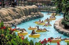 people are floating on inflatable rafts and having fun at the water park