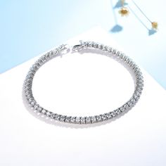 Discover the timeless elegance of our Silver Tennis Bracelet, meticulously crafted from the finest 925 Silver. This delicate piece is designed to gracefully adorn your wrist, adding a touch of sophistication to any ensemble. Key Features: Material: Premium 925 Silver, ensuring longevity and a brilliant shine. Gemstones: Embellished with sparkling Zircon (CZ) stones, available in 2.0mm or 2.5mm sizes, for a luxurious touch. Size: The bracelet is fashioned to a length of 7.4 inches or 19 cm, ensuring a perfect fit for your wrist. Durability: Features waterproof, hypoallergenic, and anti-tarnish properties, and is 100% nickel-free and lead-free, catering to sensitive skin and guaranteeing long-lasting wear. Design: A tennis bracelet, known for its slender and elegant design, adorned with a co Silver Tennis Bracelet, Luxury Bracelet, Cvd Diamond, Diamond Tennis Bracelet, Tennis Bracelet Diamond, Black Diamonds, Bracelet For Men, Skull Ring, Bracelet For Women