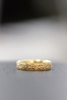 a gold wedding ring sitting on top of a table