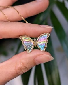 Stunning and one-of-a-kind, this Rainbow Diamond Butterfly Necklace is set with a pearl backing and mini diamonds. It is a truly stunning piece. The pearl adds an iridescent glow, with the diamonds add just the perfect amount of sparkle! Butterflies represent hope and transformation. The size is medium. 18" gold chain with adjustable slider. 26mm wide wings White Topaz (3.28ct) Diamonds (0.25ct) Mother-of-pearl doublet 14k yellow gold Iridescent Gemstone Jewelry, Iridescent Fine Jewelry As A Gift, Luxury Iridescent Jewelry For Formal Occasions, Pearl Gemstone Jewelry For Party, Party Pearl Gemstone Jewelry, Party Jewelry With Pearl And Gemstone, Pearl Jewelry With Diamond Accents As A Gift, White Gold Gemstone Jewelry With Mother Of Pearl, Dazzling Iridescent Jewelry For Gift