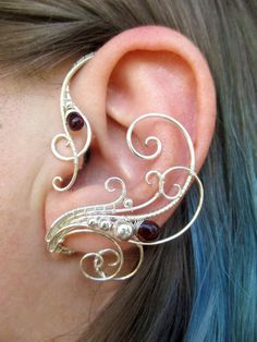 the ear is adorned with silver wire and garnets