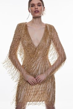 a woman in a gold fringed dress