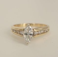 a yellow gold engagement ring set with a pear shaped diamond