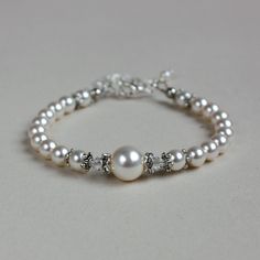 Vintage-style beaded bracelet featuring Swarovski pearls and crystals combined with sparkly rhinestone spacers. Perfect for any occasion, weddings and parties or as a gift.  Please note that although I take a great care to keep the colours on the photographs as close to reality as possible, they may look slightly different on different monitors. Materials used:  Swarovski pearls, white (4 mm, 6 mm, and 10 mm), Swarovski crystals, clear (4 mm), rhinestone spacers, silver and antique silver colour Luxury Wedding Pearl Chain Beaded Bracelets, Wedding Pearl White Beaded Bracelets, Formal White Crystal Pearl Bracelet, Wedding Pearl Bracelet With Beaded Details, White Crystal Pearl Bracelet For Formal Occasions, Formal White Beaded Crystal Bracelet, White Beaded Crystal Bracelet For Formal Occasions, White Pearl Crystal Bracelet For Wedding, Pearl White Beaded Bracelet For Wedding