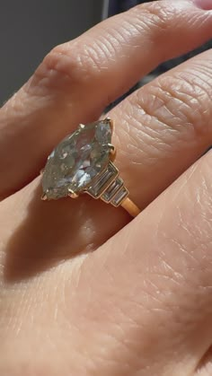 a woman's hand holding an engagement ring with a large diamond in the middle