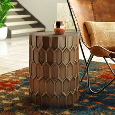 a brown chair sitting on top of a rug next to a table with a vase