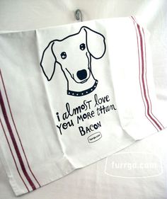 a tea towel with a dog's face on it and the words i almost love you more than bacon