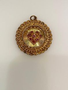 Vintage 14k yellow gold ruby heart round filigree disc with rope edge charm. The charm is 14.98 grams of gold. Yellow Gold Round Jewelry For Valentine's Day, Vintage Charm Yellow Gold Heart Pendant Jewelry, Yellow Gold Heart Pendant With Vintage Charm, Vintage Charm Heart-shaped Yellow Gold Jewelry, Yellow Gold Heart Jewelry With Vintage Charm, Victorian 14k Gold Jewelry For Valentine's Day, Antique Yellow Gold Jewelry With Heart Charm, Collectible 14k Gold Heart-shaped Jewelry, Vintage Gold Charms Stamped 14k