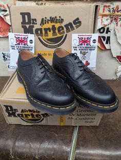 These Dr Marten shoes are quite rare. They were a style that were made in very small quantities. They are a classic brogue shoe with a twist. They have a black smooth leather with an ostrich/snake finish.  They are a modern Made in England version,and have the trademark cushioned sole with yellow stitching. The sole has been finished in a darker contrast which compliments the shoe perfectly. They are a UK size 8, European 42, Mens USA 9. Black Wingtip Oxfords For Derby, Black Wingtip Dress Shoes With Brogue Detailing, Black Wingtip Oxfords With Perforated Toe Box, Black Dress Shoes With Perforated Toe Box, Classic Leather Shoes With Round Toe And Perforations, Black Wingtip Dress Shoes With Perforated Toe Box, Black Wingtip Dress Shoes For Derby, Black Wingtip Dress Shoes With Rubber Sole, Derby Dress Shoes With Perforations And Round Toe