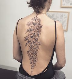 the back of a woman's body with flowers on her upper and lower back