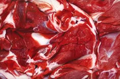 raw meat is shown in this close up photo, with red and white markings on it